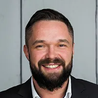 Martin Vogel – Porträt eines lächelnden Mannes im Business-Outfit